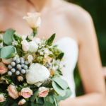 Bridesmaid with a white dress holding a wedding bouquet