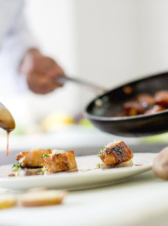 chef plating up a gourmet meal in the kitchen