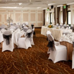 The Almond Suite at Mercure Livingston Hotel, set up for a wedding breakfast, white and grey, silver candlestick centrepieces, top table