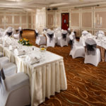 The Almond Suite at Mercure Livingston Hotel, set up for a wedding breakfast, white and grey, silver candlestick centrepieces, top table