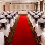 The Almond Suite at Mercure Livingston Hotel, set up for a wedding ceremony, red carpet aisle, white and black chairs