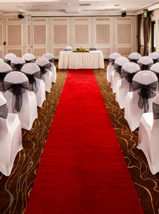 The Almond Suite at Mercure Livingston Hotel, set up for a wedding ceremony, red carpet aisle, white and black chairs