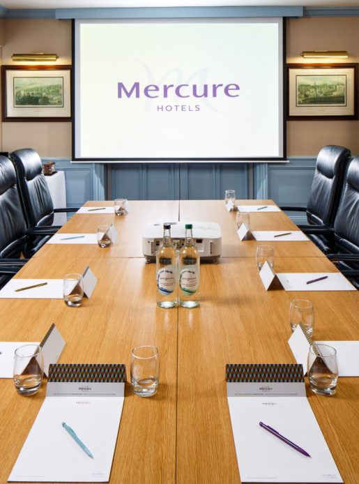The Boardroom at Mercure Livingston Hotel, set up for a meeting, projector screen
