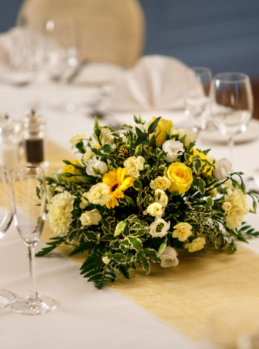 Floral centrepiece on table, wedding breakfast, yellow flowers