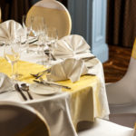 Close up of place setting at table, wedding breakfast, folded white napkin