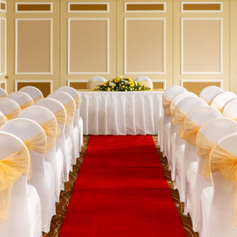 The Gillian Suite at Mercure Livingston Hotel, set up for a wedding ceremony, white and yellow theme, red carpet aisle