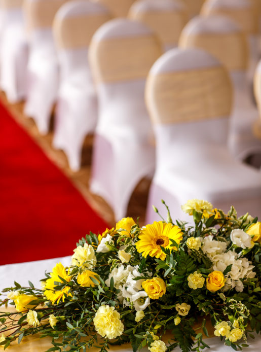 Yellow flower centrepiece, wedding ceremony, red carpet aisle